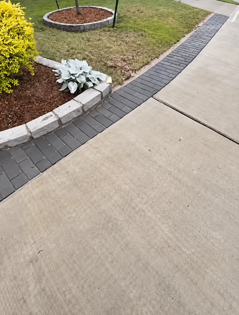 Curved brick-edged driveway extension with a paver border running along a concrete driveway in Houston