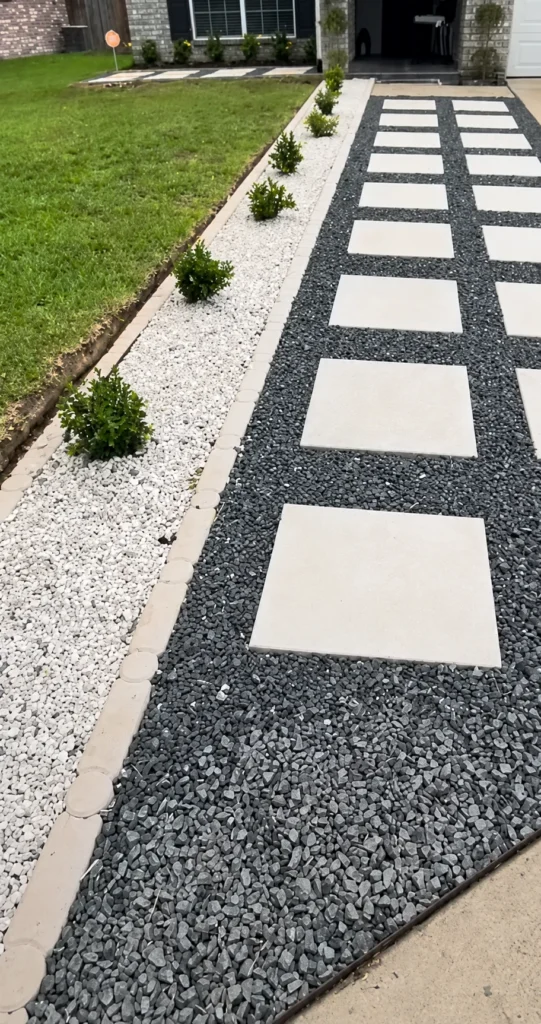 Front entry stepping stone path set in dark gravel leading from a driveway to the house